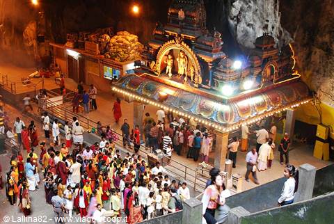 Hindu shrine inside Batu Caves, devotees queueing under bright temple lights