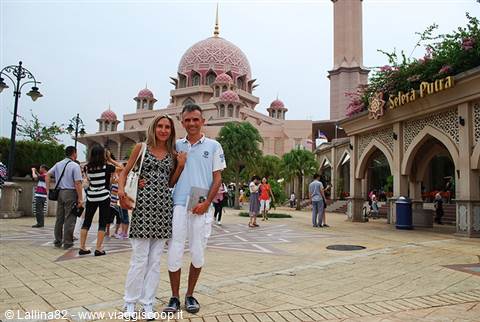 Tourist couple posing in front of the pink Putra Mosque in Putrajaya