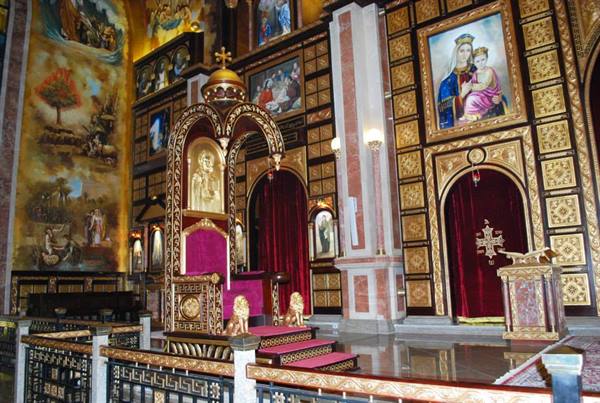 Golden iconostasis with red bishop's throne and lions, richly decorated Coptic church