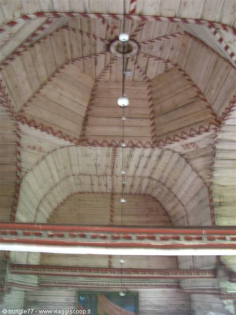 Wooden domed ceiling with red painted zigzag decorations and hanging bulbs