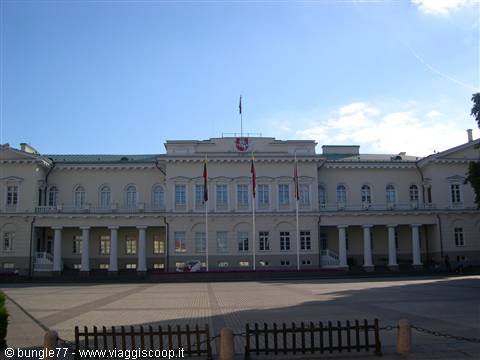 Presidential Palace in Vilnius, white classical facade with flags under blue sky