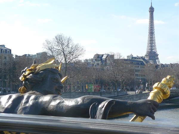 Gilded bronze statue on Alexandre III bridge with the Eiffel Tower