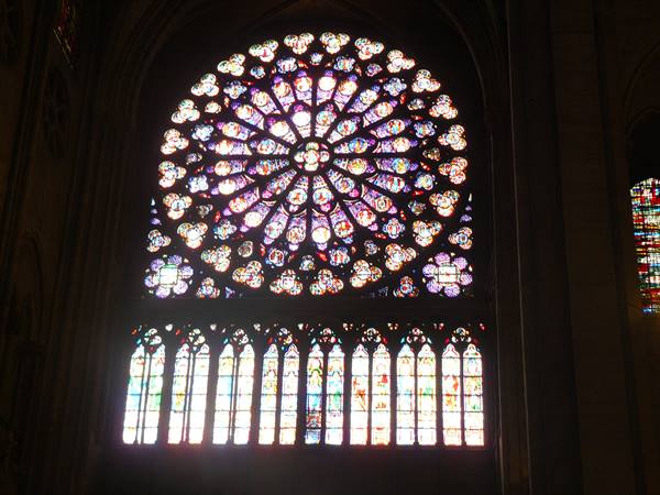 Illuminated stained glass rose window inside Chartres Gothic cathedral