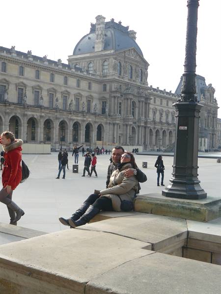 Couple sitting on stone in front of the Louvre, winter light