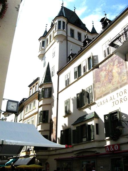 Frescoed building with protruding tower under blue sky, Casa Altor Torg sign