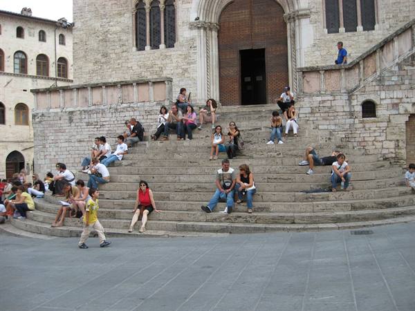 Tourists sitting on the stone steps of Perugia Cathedral