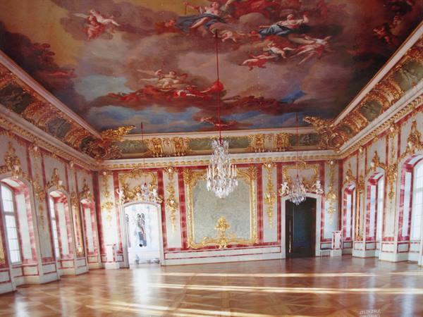 Baroque hall with frescoed ceiling, crystal chandeliers and red gilded walls
