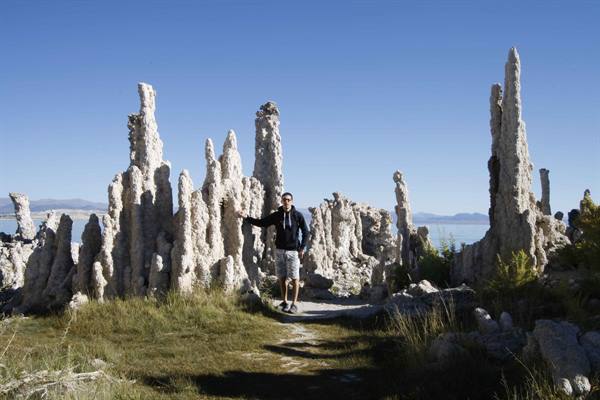 Man beside tufa limestone formations at Mono Lake under blue sky