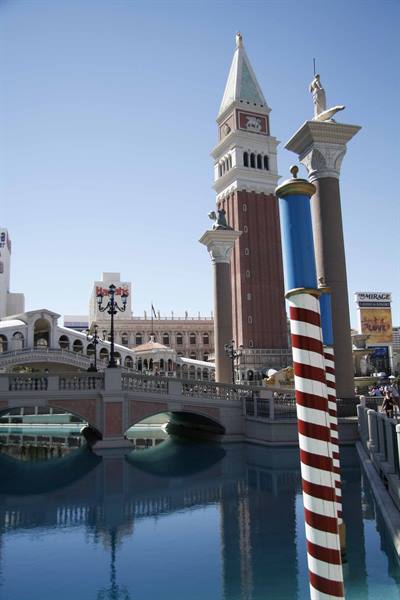 St Mark's brick bell tower and bridge over the canal, striped gondola pole