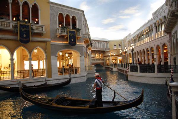 Gondolier in striped shirt rows along the Venetian's indoor canal in Las Vegas