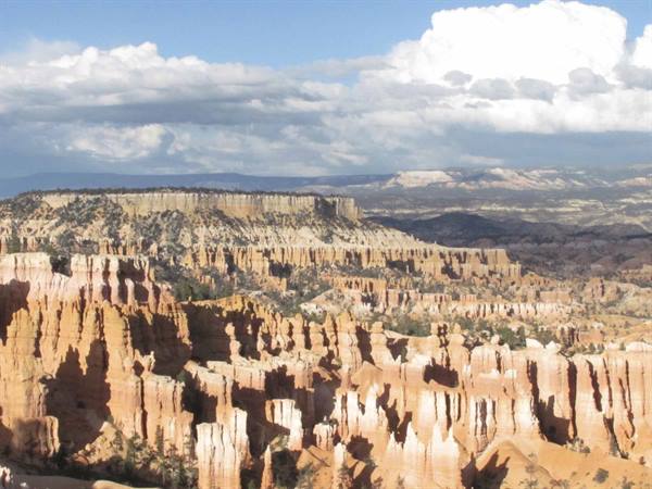 Orange and white hoodoos of Bryce Canyon under white clouds