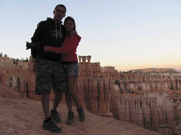 Couple with camera among the red hoodoos of Bryce Canyon at dusk