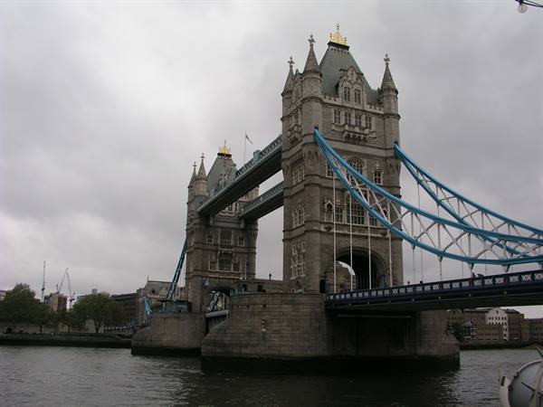 Tower Bridge in London, stone towers and blue suspension chains over the Thames
