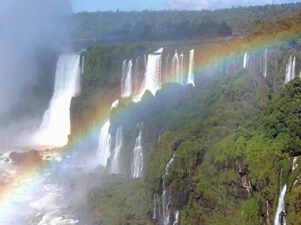 Iguazu Falls: cascades through green forest with a rainbow