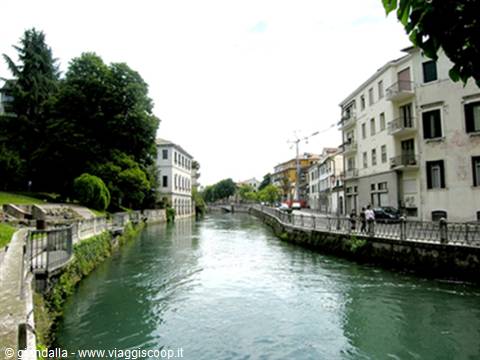 The Sile river flowing through Treviso between buildings and tree-lined banks