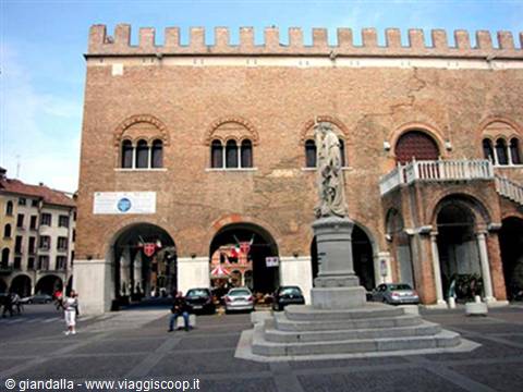 Statue on pedestal in front of the brick Palazzo dei Trecento, Treviso