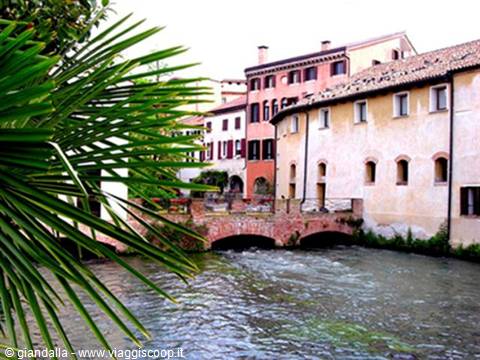 Brick bridge over the Sile river among colorful houses in Treviso
