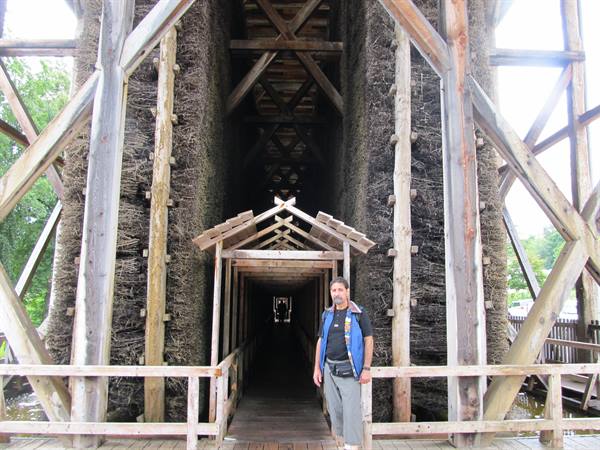 Tourist standing under the wooden walkway of a graduation tower