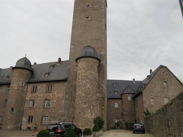 Fortress courtyard with tall stone keep and turreted domes under gray sky