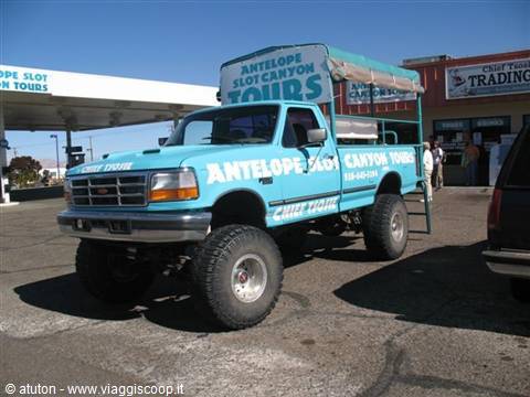 Turquoise tour truck parked at Antelope Slot Canyon Tours in sunshine