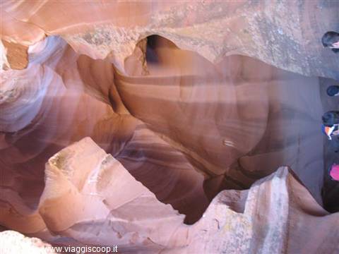 Antelope Canyon: sandstone walls carved by light, tourists watching from above