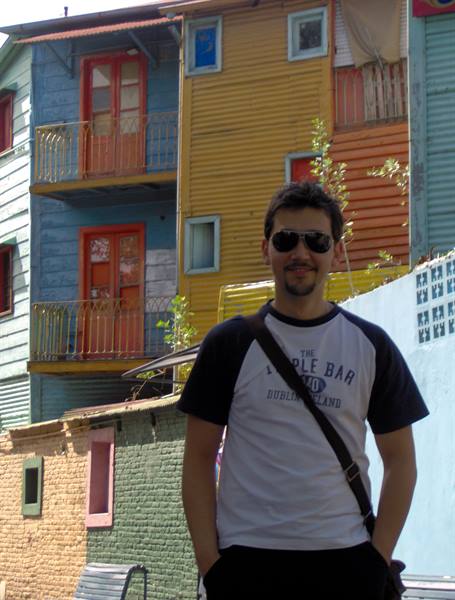 Tourist in sunglasses in front of Caminito's colorful sheet-metal houses