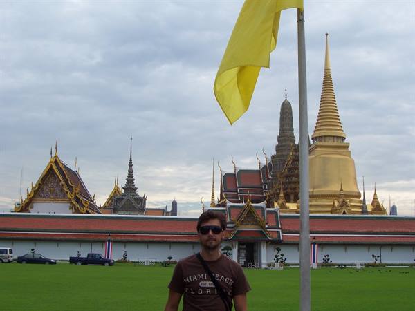 Tourist before the golden stupa of the Grand Palace in Bangkok, yellow flag