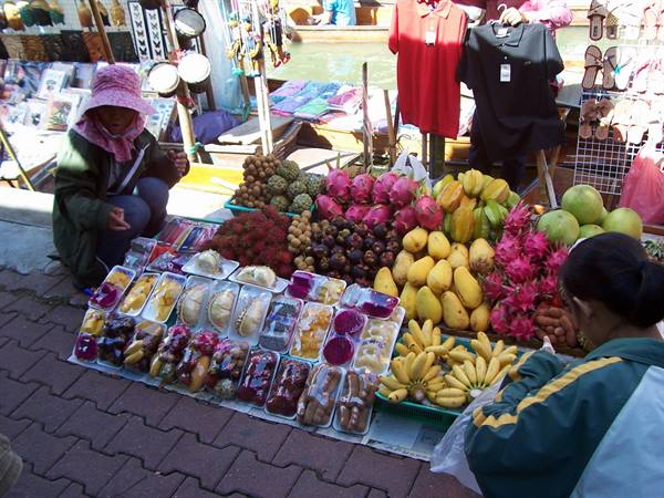 Fruit vendor at floating market, mangoes and dragon fruit on display