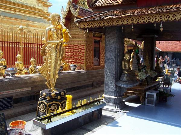 Golden Buddha statue with candles at Doi Suthep temple, Chiang Mai