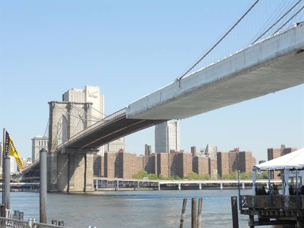 Brooklyn Bridge stone towers and steel cables over the East River, Manhattan skyline