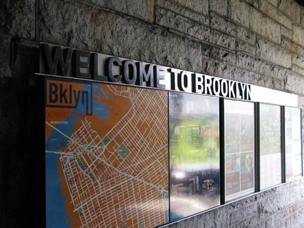 Welcome to Brooklyn sign with city map on gray stone wall