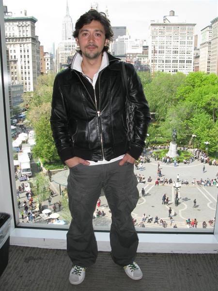Man in leather jacket by window overlooking Union Square, New York