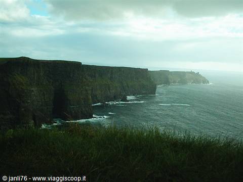 Cliffs of Moher, dark rock faces plunging into the ocean under heavy clouds