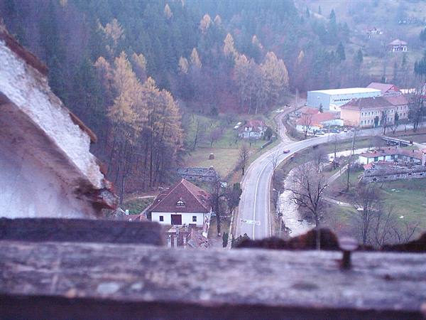 Village with road and red roofs seen through a stone window
