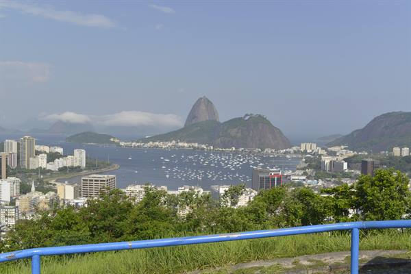 Sugarloaf Mountain and Botafogo bay with boats, from a blue railing viewpoint