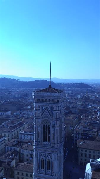 Giotto's bell tower in white and green marble above Florence rooftops