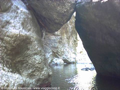 Limestone boulders forming a narrow opening above a stream pool
