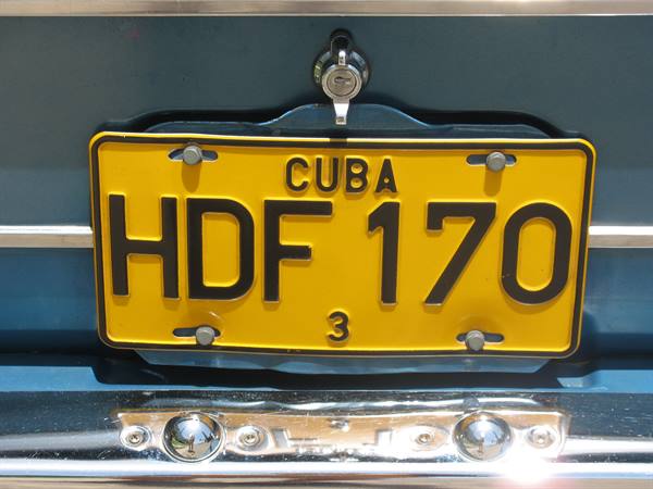 Yellow Cuban license plate HDF 170 on blue car, shiny chrome