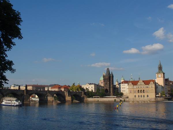 Charles Bridge with pedestrians, Gothic tower and Vltava river in Prague