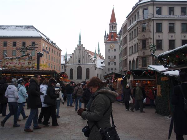 Christmas market at Munich's Marienplatz, visitors walking among snowy stalls
