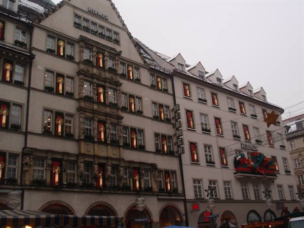 Hirmer department store in Munich with Christmas decorations, lit windows, grey sky