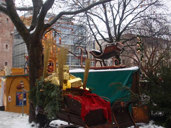 Snow-covered wooden sleigh with red cloth at Munich Christmas market