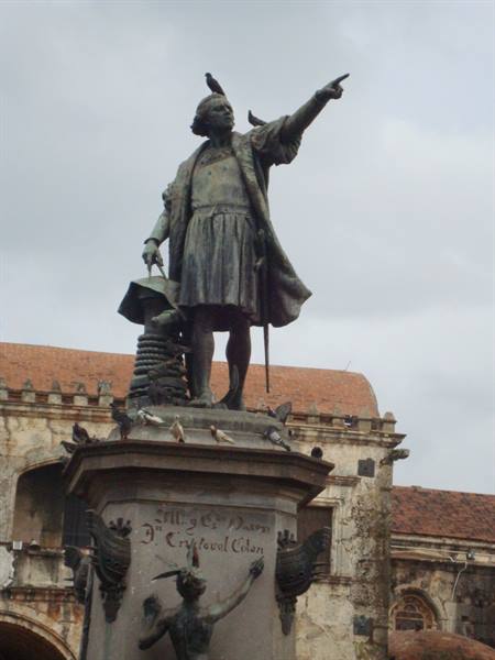 Bronze statue of Christopher Columbus pointing, pigeons on pedestal, Santo Domingo