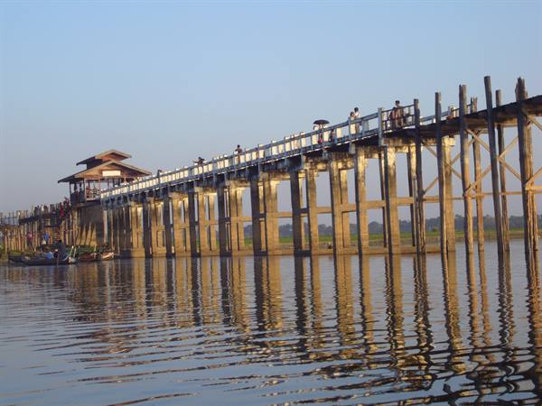 U Bein teak wooden bridge over the lake, reflections on calm water