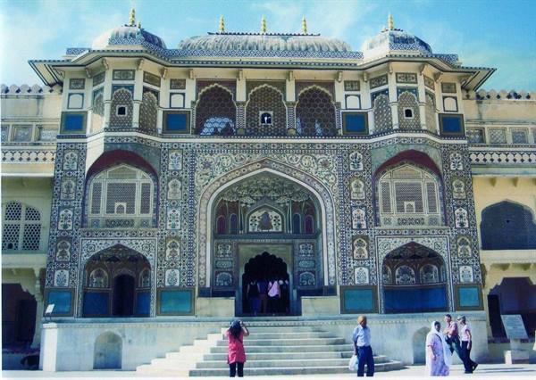 Tourists photograph the mosaic-decorated facade of Amber Fort, Jaipur