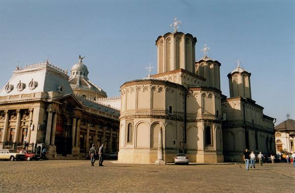 Timișoara Metropolitan Cathedral, white towers with crosses, people walking on square