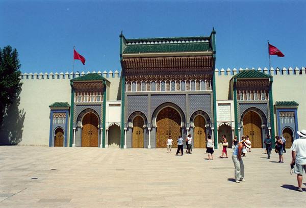 Tourists walking in front of the ornate brass doors of Fez Royal Palace, Morocco