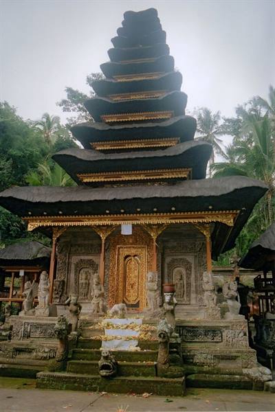 Balinese temple with tiered thatched pagoda roof and golden gateway