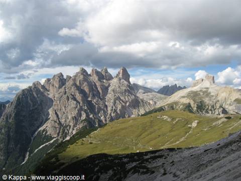 Cadini di Misurina, Dolomites: rocky peaks rising above green meadows under clouds