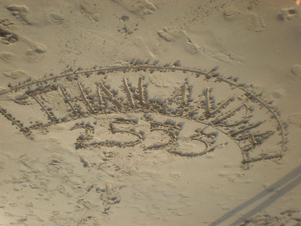 Thailand 2555 written in the wet sand on the beach